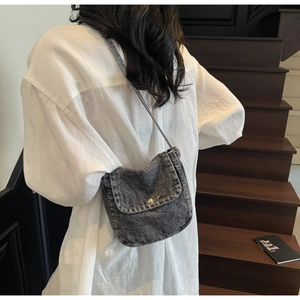 Detail of retro washed denim crossbody bag in dark gray with silver metal snap button