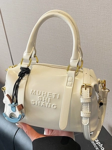 Sac Boston blanc crème avec lettrage gaufré et breloque cheval pour le trajet