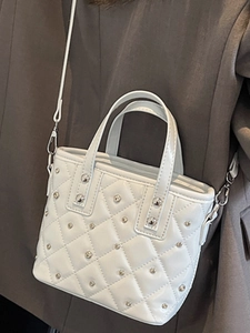 Elegant white quilted bucket bag with silver studs and adjustable crossbody strap