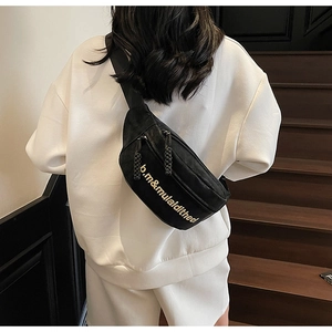 Vue arrière d'un sac bandoulière noir en toile avec lettrage doré sur un sweat blanc
