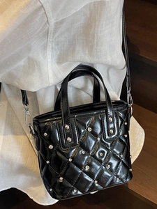 Chic black quilted bucket bag with shiny finish and silver rivet details for women