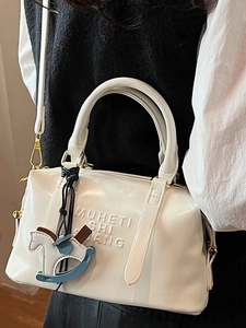 Sac Boston blanc minimaliste avec lettres gaufrées et pendentif cheval à bascule