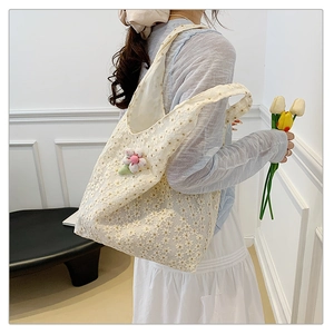Detail of white lace tote bag with floral embroidery and pink 3D flower charm