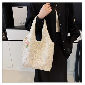 Detail of white lace tote bag with 3D floral embroidery and a plush flower keychain