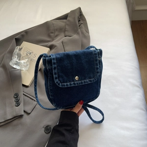 Detail of blue denim mini crossbody bag with metal buckle and stylish shoulder strap
