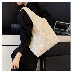 Detail view of white lace tote bag with floral embroidery and canvas lining