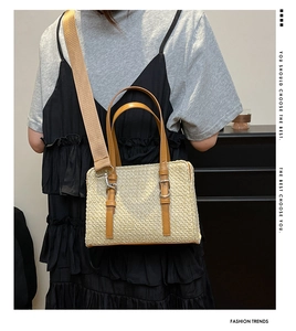 Straw patchwork handbag with brown leather strap shown on a model for scale and style