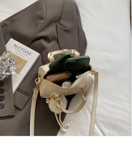 Detail view of beige crocodile embossed boston bag showing spacious interior with personal items