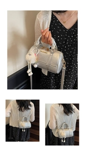 Detail of silver crocodile-embossed pillow bag with gold hardware and plush charm