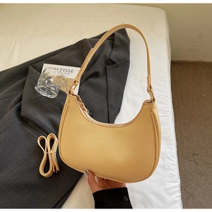 Detail of beige crescent hobo bag with adjustable strap and light gold zipper