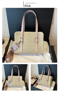 Detailed view of pink leather trim on beige straw shoulder bag inside a gift box