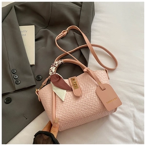 Détail du sac seau rose tressé avec poignée en foulard et fermoir doré chic