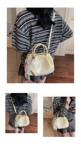 Detail of yellow pleated shoulder bag with pearl lace bow charm and glossy finish