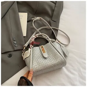 Vue détaillée du sac seau tressé argenté avec boucle magnétique et foulard en soie