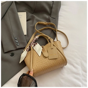 Vue détaillée du sac à main tissé kaki avec foulard en soie et fermoir doré