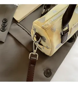 Dettaglio della ferramenta argentata e della trama con cuori sulla borsa Boston