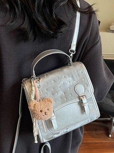 Silver sequin backpack with plush bear charm, versatile for stylish casual commuting use