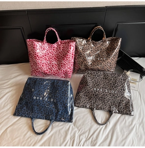 Quatre sacs cabas imperméables à motif léopard en rose, beige, bleu et gris foncé à plat