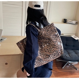 Gros plan détaillé d'un sac cabas léopard avec couche en PVC et texte E BAG décoratif