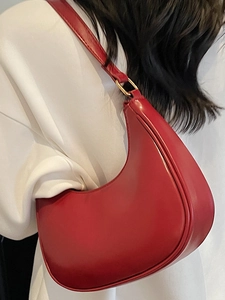 Elegant red crescent shoulder bag made of matte leather with gold metal rings for women