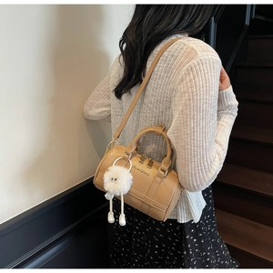 Elegant khaki pillow handbag with leather texture and cute plush monster charm detail