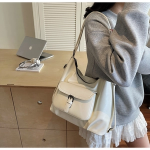 Detail view of large cream tote bag with stylish buckle pocket and premium leather texture