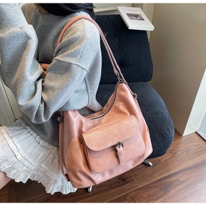 Detail of the pink leather tote bag featuring a metal buckle pocket and adjustable strap