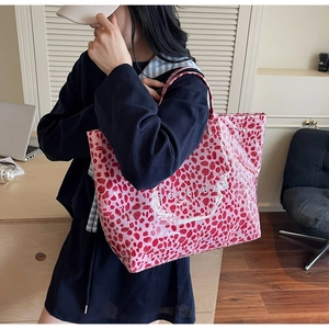 Détail du grand sac cabas rose à imprimé léopard avec texte porté par un mannequin