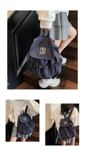 Three views of a navy nylon backpack with embroidery on a wooden staircase background