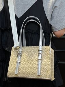 Women's straw woven tote bag with silver metal handles and adjustable shoulder strap