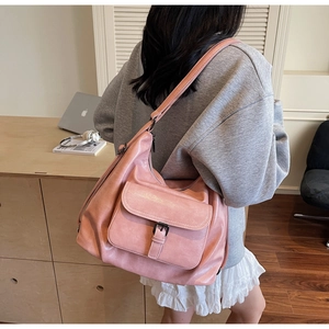 Detail view of pink leather tote bag with stylish metal buckle and large pocket