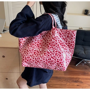 Détail du sac cabas à imprimé léopard rose avec finition brillante imperméable à l'épaule