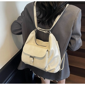 Detailed view of cream PU leather backpack featuring metal buckles and soft texture