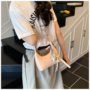 Pink glossy hobo bag detail featuring silver star pendant and metallic chain strap