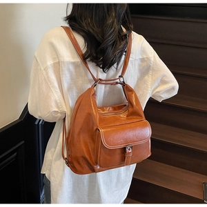 Detail of vintage brown leather backpack with metal buckle and smooth glossy finish