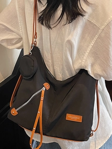 Fashionable black nylon crescent tote bag with brown leather straps and coin purse
