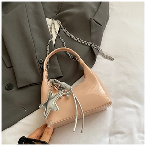 Detail of glossy pink patent leather hobo bag with silver chain and star charm detail