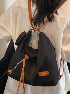 Versatile black nylon tote backpack with brown leather straps and front zipper pocket