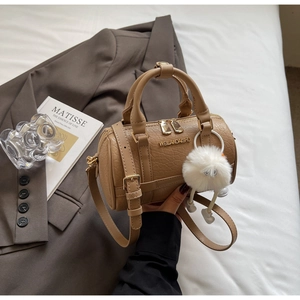 Detailed view of khaki crocodile embossed mini pillow bag with elegant metallic logo