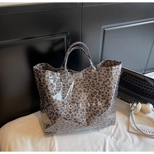 Gros plan détaillé du sac cabas léopard avec texte blanc sur un lit blanc épuré