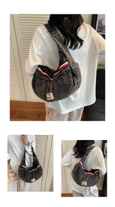 Detail view of crescent moon shape denim shoulder bag with red white blue side webbing