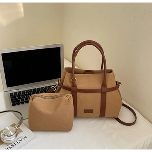 Détail du sac cabas en toile kaki avec poignées en cuir marron et petite pochette assortie