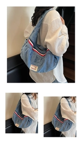 Detail of light blue denim hobo bag with red-white stripes and woven brand label