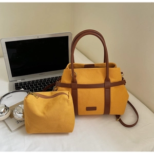Détail du sac seau en toile jaune avec poignées en cuir marron pour le trajet quotidien
