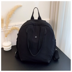 Close-up of black waterproof backpack with metal DD logo and adjustable shoulder straps