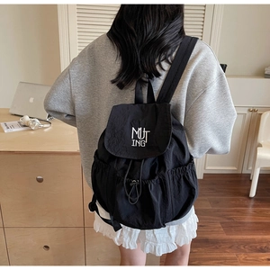Rear view of a black nylon backpack featuring MUTING embroidery and drawstring closure