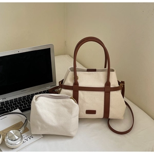 Détail d'un ensemble de sacs seau en toile avec garniture en cuir et petite pochette zippée