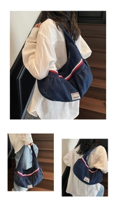 Detailed close-up of dark blue denim hobo bag with red-white stripes and logo label