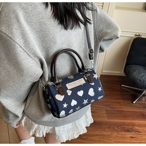 Dettaglio della borsa Boston con stampe di cuori e stelle bianche su nylon blu scuro