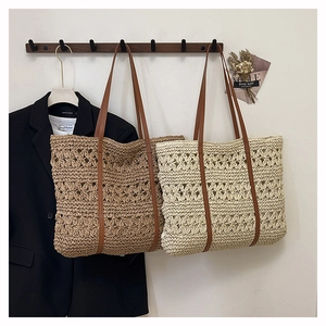 Detailed close-up of handmade woven straw tote bags in beige and khaki with leather handles